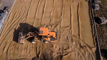 tractor amarillo repara la vista aérea de la carretera foto