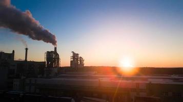 Sunrise over the factory. The smoke comes from the pipes at dawn. photo