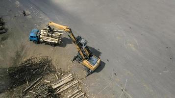 the loader loads the wooden beams in the truck photo