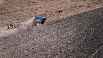 tractor plowing field top view, aerial photography with drone photo
