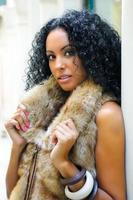 Young black woman, model of fashion, wearing fur vest photo