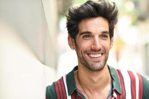 joven atractivo con cabello oscuro y peinado moderno con ropa informal al aire libre foto
