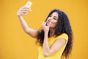 Young Arab woman taking selfie photograph with smartphone.