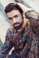 Young bearded man, model of fashion, wearing shirt in urban background. photo