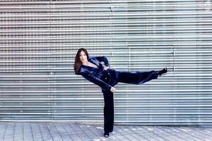 mujer con traje azul posando cerca de un moderno edificio de metal. foto