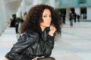 Funny black female model at fashion sitting on a bench photo