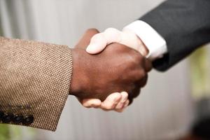 Black businessman shaking hands with a caucasian one photo