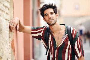 joven atractivo con cabello oscuro y peinado moderno con ropa informal al aire libre foto