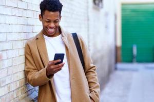 joven negro usando su teléfono inteligente al aire libre. foto