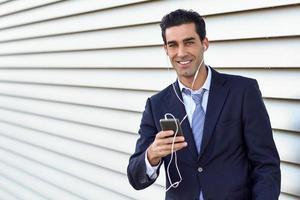 hombre de negocios con traje azul y corbata usando un teléfono inteligente. foto