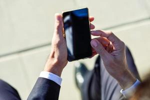 Businessman using his smartphone in the street photo