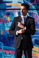 Young businessman wearing blue suit and tie in urban background photo