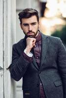 Young bearded man in urban background wearing british elegant suit in the street. photo