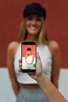 Woman hand taking photograph with a smartphone to her friend photo