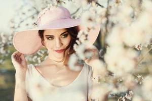 Portrait of young woman in the flowered garden in the spring time photo