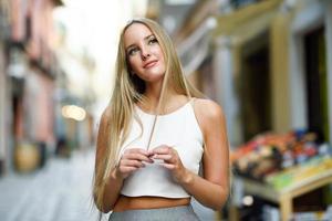 Beautiful young blonde woman in urban background. photo