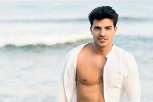 Portrait of an attractive young man on a tropical beach photo