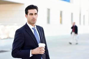 Businessman drinking coffee to go with a take away cup photo