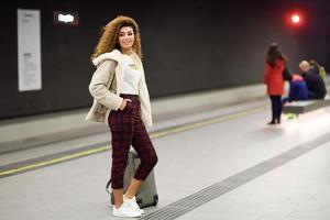 Young arabic woman waiting her train in a subway station. photo