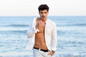 Portrait of an attractive young man on a tropical beach photo