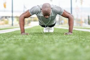 Fitness black man exercising push ups in urban background photo