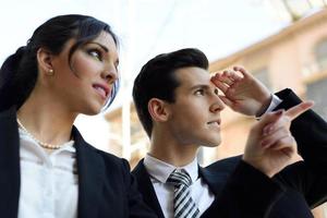 Attractive business people looking at something interesting. Couple working. photo