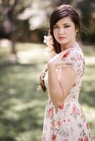 joven y bella mujer japonesa con flores rosas y rojas foto