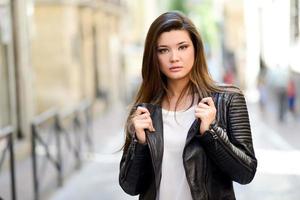 hermosa mujer japonesa en fondo urbano con chaqueta de cuero foto