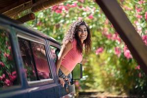 chica árabe feliz asomándose por la ventana de una furgoneta foto