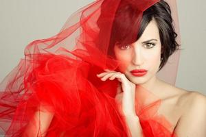 Beautiful girl with a red tulle. Studio photograph photo