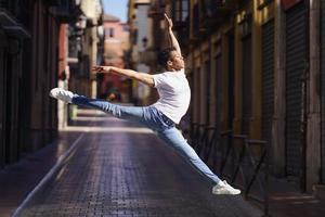 hombre atlético negro haciendo un salto acrobático al aire libre foto