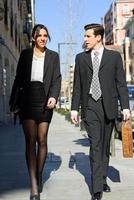 Attractive business people walking on the street. Couple working. photo