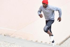 hombre negro corriendo arriba al aire libre en el fondo urbano foto