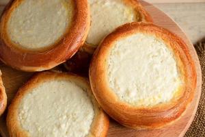 Homemade buns with cottage cheese on wooden background. photo