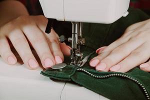mujer diseñadora o sastre trabajando en máquina de coser. foto