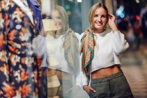 Blonde girl smiling with defocused urban city lights at night photo