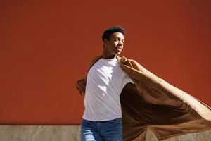 joven negro bailando en la pared urbana roja. foto