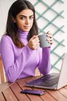 Persian woman on her balcony using laptop computer photo