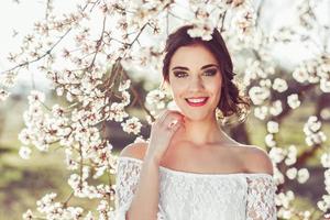 Portrait of young woman in the flowered garden in the spring time photo