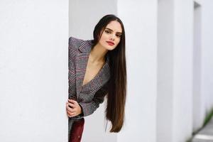 hermosa chica con el pelo muy largo con abrigo de invierno y gorra al aire libre. foto