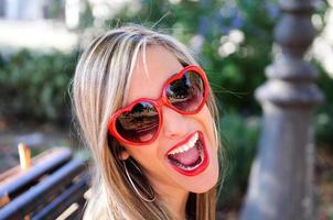 Funny girl with red heart glasses photo