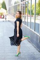 Attractive woman wearing skirt and green high heels outdoors. photo