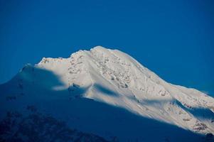 Oeak of the mountain illuminated by the sun photo