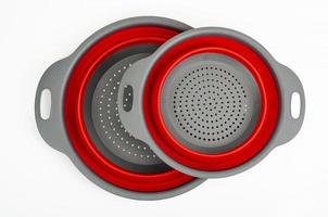 Bicolor collapsible colander on white background. Studio Photo