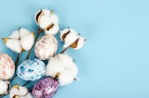 Easter background, color handmade eggs on blue background, decorated with cotton, space for text. Happy holiday. Studio Photo