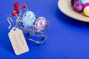 Grocery supermarket cart filled with chicken eggs. Concept of preparing for Easter, buying food. Space for text. Studio Photo