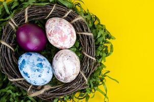 Top view of color easter haqndmade eggs and nest flatlay. Trendy minimal design spring background. Space for text. Stuio Photo