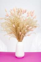 Minimalist white vase with dried up flowers. Studio Photo