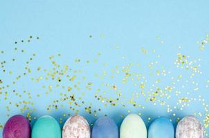 Decorated handmade Easter eggs for the holiday season on blue background. Creative minimal abstract concept. Studio Photo