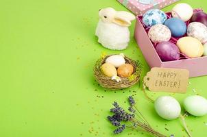 Multicolored eggs in open gift box. Concept of the Happy Easter holiday, greeting card template. Studio Photo
